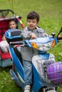 Little boy on a scooter with girl in cart on Royalty Free Stock Photo