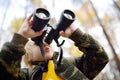 Little boy scout with binoculars during hiking in autumn forest. Child is looking through a binoculars Royalty Free Stock Photo