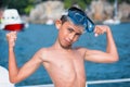 Little boy with scuba mask showing muscles