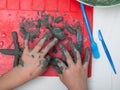 Little boy sculpts from clay with interest. Pottery workshop for kids, raw clay, sculpting tools, glazing and painting clay.