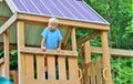 Little boy on second story of a playhouse, looking down. Royalty Free Stock Photo