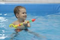 Little boy shooting with water gun in the swimming pool Royalty Free Stock Photo