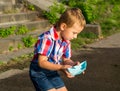 A little boy is holding a paper boat in his hands and is going t Royalty Free Stock Photo
