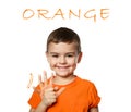 Little boy showing word ORANGE on white. Sign language