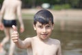 A little boy shows a thumbs up like in the middle of frozen water droplets in the air