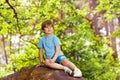 Little boy sit on stone in the forest Royalty Free Stock Photo