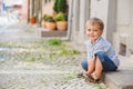 Little boy sits on the doorstep on a city street Royalty Free Stock Photo