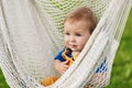 A little boy sits in a hammock on a summer day in the garden Royalty Free Stock Photo