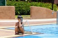 The little boy sits near the swimming pool. Royalty Free Stock Photo