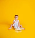 A little boy sits in a T-shirt and underpants next to a big gift box