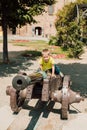 A little boy sits on top of a historic cannon