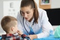 Little boy sitting at appointment of woman pediatrician in clinic