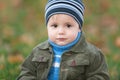 Little boy sitting on the autumn grass