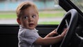 Little boy sitting behind the wheel of a car close-up