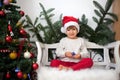 Little boy, sitting on a bench under christmas tree, eating choc Royalty Free Stock Photo