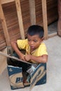 Little boy sitting in a box in the village