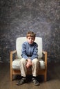 Little boy sitting on chair in studio