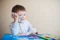 Little boy sitting at desk and talking on the phone Royalty Free Stock Photo