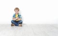 Little boy sitting on floor leaning against wall Royalty Free Stock Photo