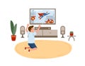 Little boy sitting on floor and watching superhero movie, action film or television channel for children on TV set. Home