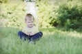 Little boy sitting in the grass outdoors Royalty Free Stock Photo