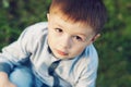 Little boy sitting on the grass in park outdoors Royalty Free Stock Photo