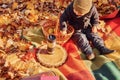 Little boy is sitting on the ground in the autumn forest