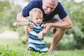 A little boy sitting on his father, balancing