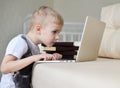 Little boy sitting with laptop on the couch at home Royalty Free Stock Photo