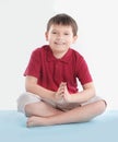 Little boy is sitting in the Lotus position.isolated on white Royalty Free Stock Photo