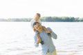 Little boy sitting on my dad`s neck on the background of the lake Royalty Free Stock Photo