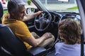 Little boy sitting near his father inside of vehicle