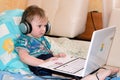 Little boy sitting playing on laptop Royalty Free Stock Photo