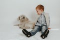 A little boy is sitting, playing with a white dog Royalty Free Stock Photo
