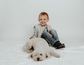 A little boy is sitting, playing with a white dog Royalty Free Stock Photo