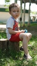 Little boy sitting on the stump in playground