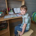 Little boy sitting at the table doing school homework. Education. Royalty Free Stock Photo