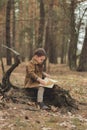 Little cute child is reading in the Forrest