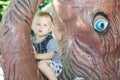 Little boy sitting on trunk of mammoth sculpture