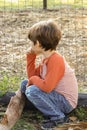 Little boy sitting by the wire mesh fence looking at something Royalty Free Stock Photo