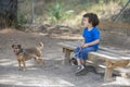 Laughing boy sitting on park bench with his little dog