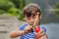 Little boy with slingshot in forest is aiming Royalty Free Stock Photo