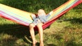 Little Boy smiles enjoying sun rays in hammock