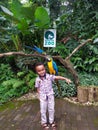 little boy smiling happily while taking pictures with birds at the Bandung Zoo.