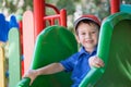 Little boy smiling on a playground outdoors in summer. Having fun on a slide. Royalty Free Stock Photo