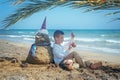 Little boy and Snowmen at tropical ocean beach in santa hat. New Years and Christmas holiday in hot countries concept Royalty Free Stock Photo