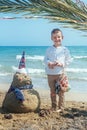 Little boy and Snowmen at tropical ocean beach in santa hat. New Years and Christmas holiday in hot countries concept Royalty Free Stock Photo