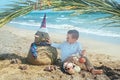 Little boy and Snowmen at tropical ocean beach in santa hat. New Years and Christmas holiday in hot countries concept Royalty Free Stock Photo