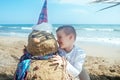 Little boy and Snowmen at tropical ocean beach in santa hat. New Years and Christmas holiday in hot countries concept Royalty Free Stock Photo