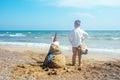 Little boy and Snowmen at tropical ocean beach in santa hat. New Years and Christmas holiday in hot countries concept Royalty Free Stock Photo